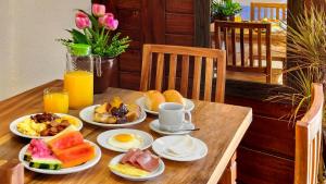 uma mesa de madeira com pratos de comida para o pequeno-almoço em Pousada União em Jericoacoara