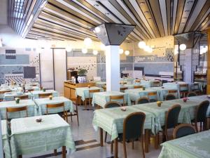 een eetkamer met witte tafels en stoelen bij Hotel Montecarlo in Chianciano Terme