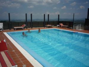 zwei Personen schwimmen in einem großen Pool in der Unterkunft Hotel Montecarlo in Chianciano Terme