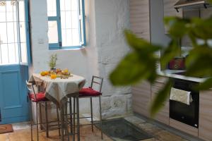 een keuken met een tafel met stoelen en een fornuis bij Il-Mezzanine in Cospicua