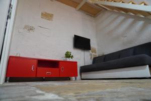 a living room with a red cabinet and a couch at Il-Mezzanine in Cospicua
