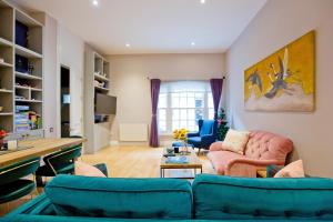 a living room with two blue couches and a table at 3 Bedroom Modern Mews House in London