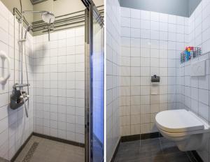 un baño con inodoro y ducha en Villa La Chatelaine, en Egmond aan Zee 20 fotos más