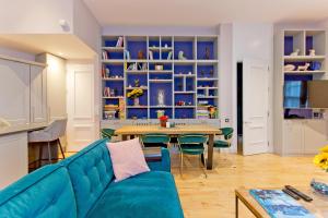 een woonkamer met een blauwe bank en een tafel bij 3 Bedroom Modern Mews House in Londen