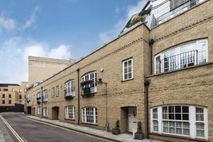 - un grand bâtiment en briques avec des fenêtres donnant sur une rue dans l'établissement 3 Bedroom Modern Mews House, à Londres