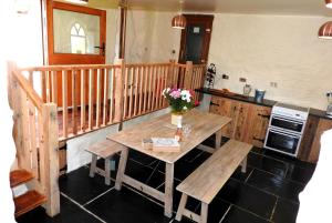 una cocina con una mesa de madera con flores. en SAUNTON SUNSHINE COTTAGE 3 Bedrooms en Braunton