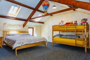 a bedroom with two bunk beds in a attic at SAUNTON SUNSHINE COTTAGE 3 Bedrooms in Braunton