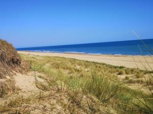 a sandy beach with the ocean in the background at Sea View Holiday Chalet, access to sandy beach - Pets go free in Winterton-on-Sea