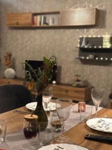 a wooden table with wine glasses and a vase with flowers at Luxury Apartments Studenets in Pamporovo