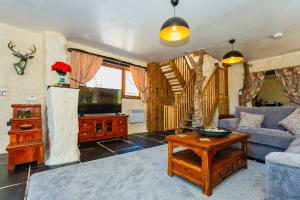 a living room with a couch and a tv at SAUNTON SUNSHINE COTTAGE 3 Bedrooms in Braunton