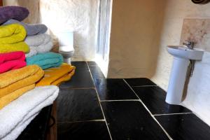 a bathroom with a sink and a bunch of towels at SAUNTON SUNSHINE COTTAGE 3 Bedrooms in Braunton +37 photos