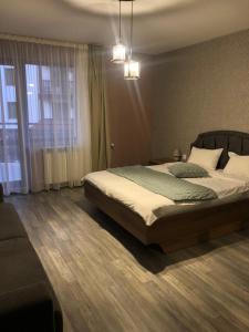 a bedroom with a bed and a large window at Luxury Apartments Studenets in Pamporovo