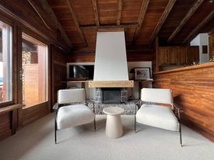 a living room with two chairs and a fireplace at Superb Attic Apartment in Les Esserts in Verbier