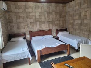 a room with two beds in a room with a wall at Pousada Mar & Sol de Camburi in Camburi