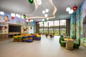 una sala de espera para niños con sillas coloridas y una gran ventana en Movenpick Living Istanbul Camlivadi, en Estambul