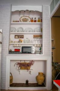 a kitchen with a microwave and a shelf with dishes at AREZA Con GARAJE in Zamora