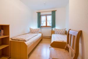 a small room with two beds and a window at Ferienwohnung Kühn in Oberstdorf