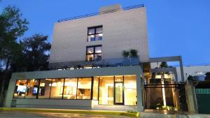 a building with large glass windows on a street at Ferrol Apart Hotel in Funes