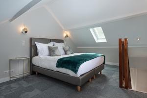 1 dormitorio con 1 cama con manta verde en Domaine et Golf de Vaugouard - La Maison Younan en Fontenay-sur-Loing
