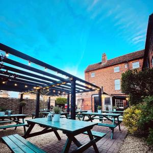 a group of picnic tables in front of a building at The Coach House in Potton