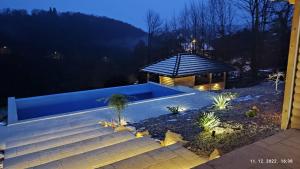 a backyard with a swimming pool and a gazebo at night at Laganini Country in Samobor