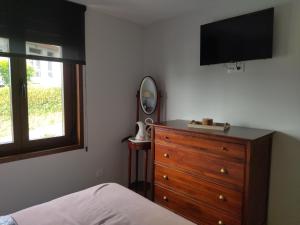 a bedroom with a dresser and a flat screen tv at Casanova in Fene
