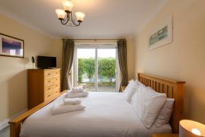 a bedroom with a bed with white towels on it at Porth Veor Manor Villas & Apartments in Newquay