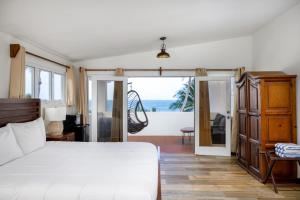 a bedroom with a bed and a view of the ocean at Casa Isleña in Rincon