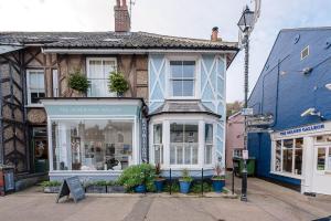 a building with a store in the middle of a street at Pelican Cottage, Aldeburgh in Aldeburgh