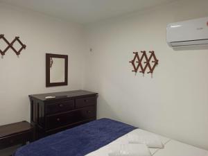 a bedroom with a bed and a dresser and a mirror at Privê Recanto da Enseada - Serrambi in Porto De Galinhas
