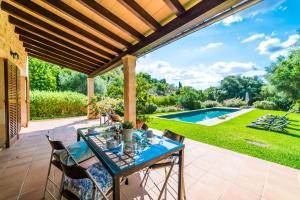 カンパネにあるIdeal Property Mallorca - Sa Velaのパティオ(テーブル、椅子付)、スイミングプールが備わります。