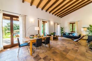 カンパネにあるIdeal Property Mallorca - Sa Velaのリビングルーム(木製テーブル、椅子付)