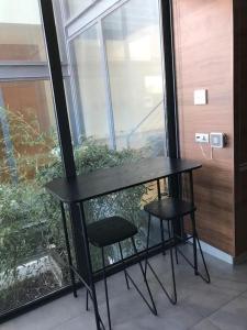 einem schwarzen Tisch und zwei Hocker vor einem Fenster in der Unterkunft Sunray Village T5 - Quinta do Lago/Vale do Lobo in Faro