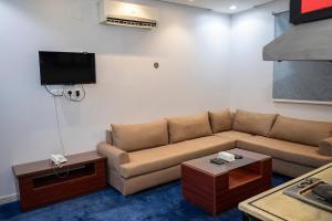 a living room with a couch and a tv at Ahlin Suites 5 in Riyadh