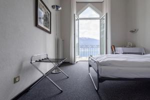 a bedroom with a bed and a large window at Hotel Monte Verità in Ascona