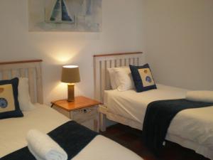 a bedroom with two beds and a lamp on a table at Albatros Holiday Home in Paternoster