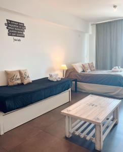 a room with two beds and a table in it at Manzanares Suites in Buenos Aires +23 photos