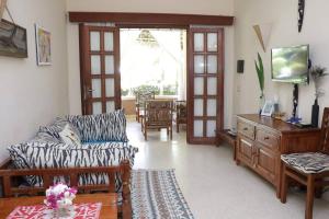 - un salon avec un canapé et une table dans l'établissement Tembo Beach Cottage, à Malindi