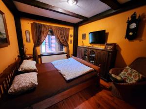 1 dormitorio con 1 cama, TV y ventana en Rancho Wilga, en Wilga