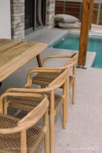 a wooden table and chairs next to a pool at Villa Vrachos luxury Living in Vrachos