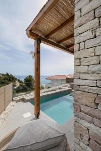 a patio with a swimming pool and a wooden pergola at Villa Vrachos luxury Living in Vrachos
