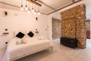 sypialnia z dużym łóżkiem i kamienną ścianą w obiekcie " Art Loft d'Exception " au Cœur de Cannes - 90m de Design et de Confort w Cannes