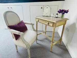 escritorio con silla y mesa con almohada morada en Barn Cottage -Westerlands en Graffham