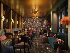 a restaurant with couches and tables and a floral wall at The Other House Residents Club- South Kensington in London