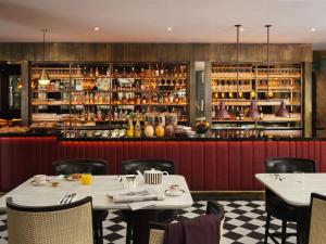 a restaurant with a table and chairs and a bar at The Other House South Kensington in London
