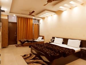 a bedroom with a bed and a desk in it at Hotel Orange Classic in Rishīkesh
