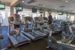 a group of people running on treadles in a gym at Edgewater Beach & Golf Resort by Panhandle Getaways in Panama City Beach