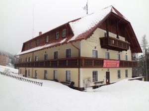 un bâtiment avec un toit enneigé dans la neige dans l'établissement Frühstückspension Koderholt, à Mönichkirchen