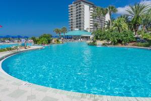 a swimming pool at a resort with blue water at Edgewater Beach & Golf Resort by Panhandle Getaways in Panama City Beach