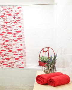 een badkamer met een rode handdoek en een bad bij Casa dos chocalhos-Piscina-Perto Praia Fluvial-Vista incrível e sossego in Mértola